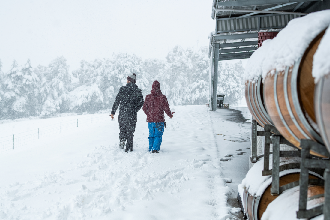 Rikard employees walking past barrells in the snow